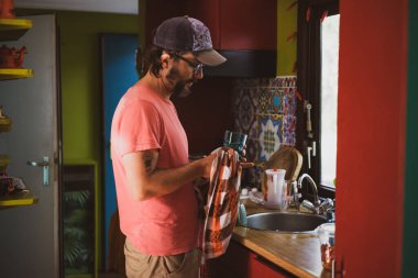 Adam evde bulaşık yıkıyor. 