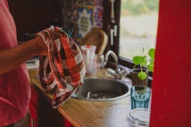 Adam evde bulaşık yıkıyor. 