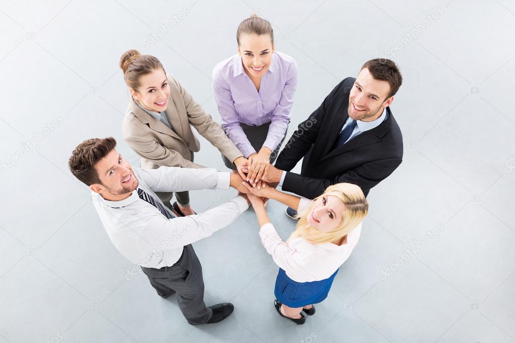 Young business people joining hands in circle