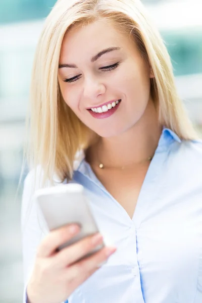 Young woman holding mobile phone — Stock Photo, Image