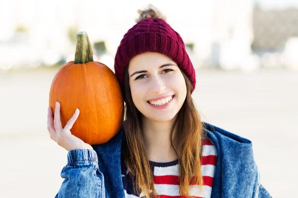 Jonge vrouw met een pompoen — Stockfoto