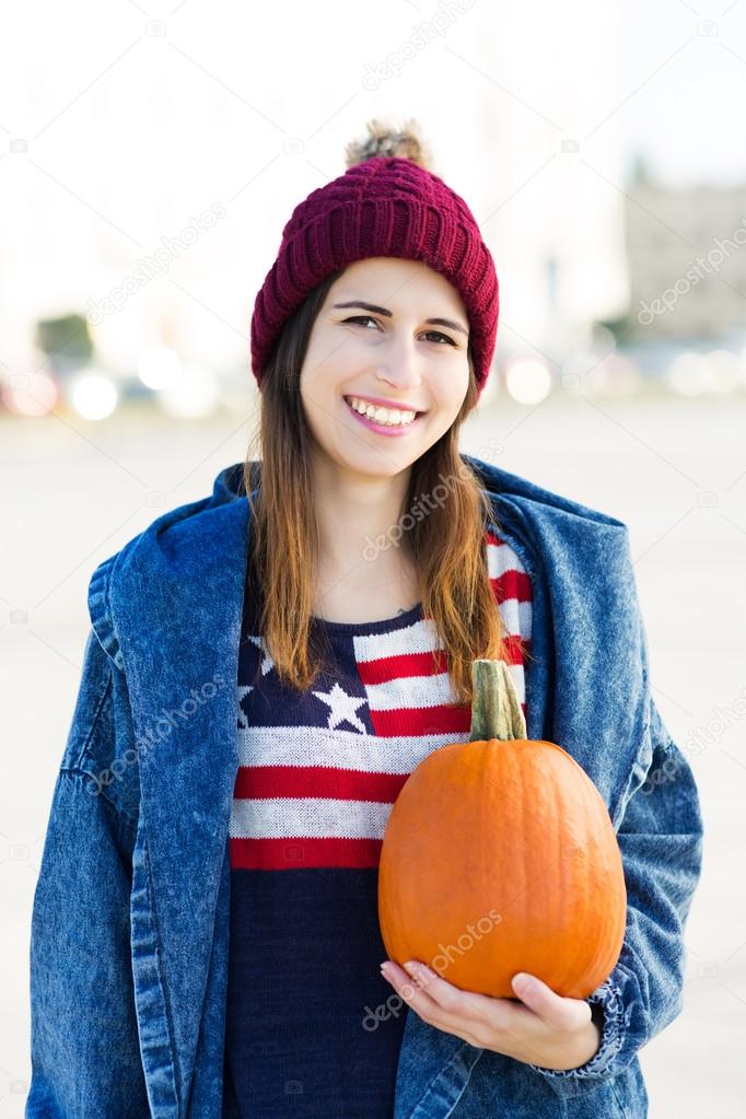 Young woman holding a pumpkin