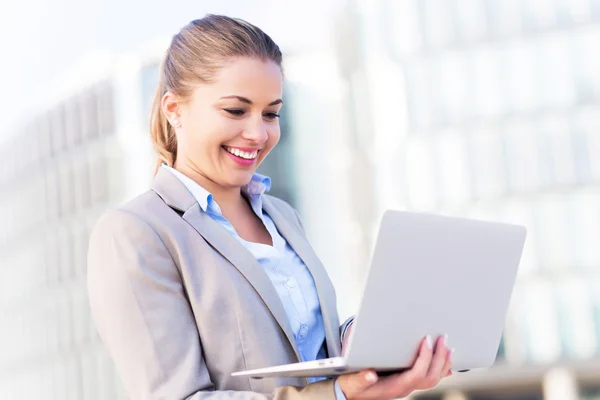 Jonge zakenvrouw bedrijf laptop — Stockfoto