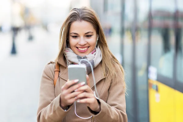 Mujer escuchando música y sonriendo —  Fotos de Stock