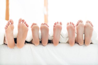 Feet of family in bed clipart
