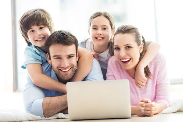 Familia feliz con portátil — Foto de Stock