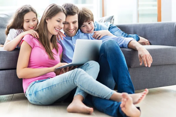 Família feliz com laptop — Fotografia de Stock