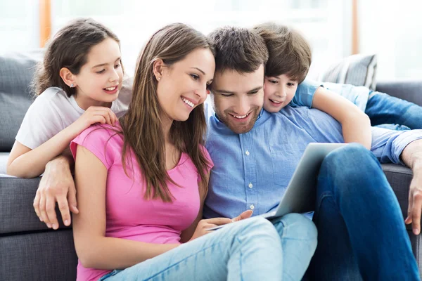 Familia feliz con portátil — Foto de Stock