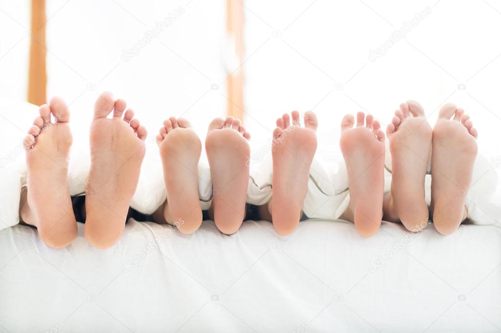 Feet of family in bed