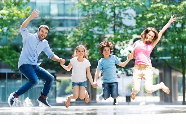 Happy young family jumping — 스톡 사진