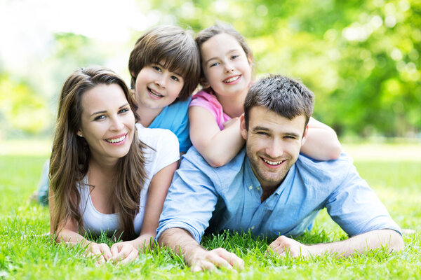 Happy young family lying on grass