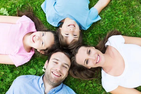 Happy family on grass, top view — Stockfoto