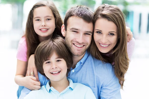 Onnellinen nuori perhe halaus — kuvapankkivalokuva