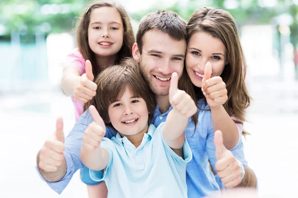 Happy young family thumbs up — Stockfoto