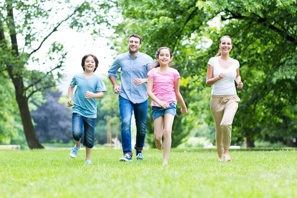 Happy young family running — Stockfoto