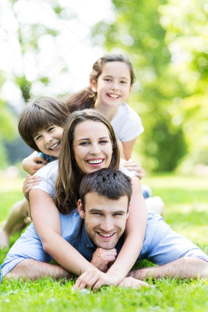 Happy young family lying on grass