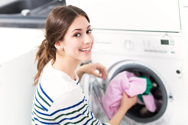 Mujer cargando lavadora — Foto de Stock