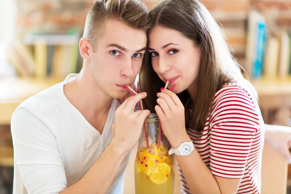 Casal jovem compartilhando uma bebida — Fotografia de Stock