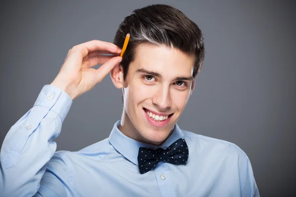 Joven sostiene lápiz en la oreja — Foto de Stock