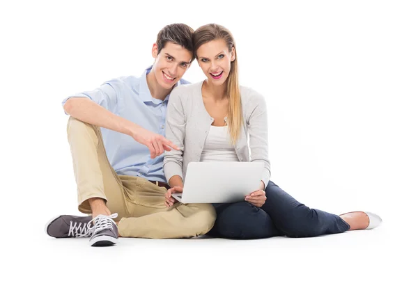 Pareja joven usando portátil — Foto de Stock