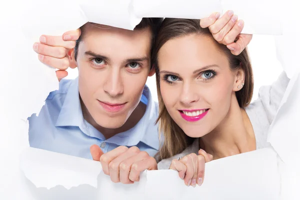 Couple peeping through hole on paper — Stock Photo, Image