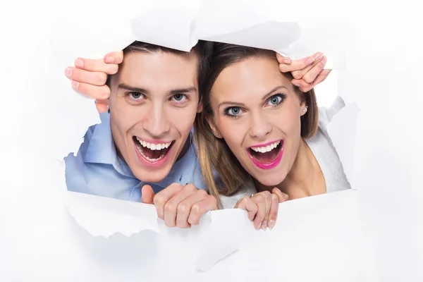 Couple peeping through hole on paper — Stock Photo, Image