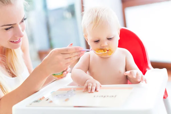 Madre alimentando al bebé con cuchara Fotos de stock libres de derechos