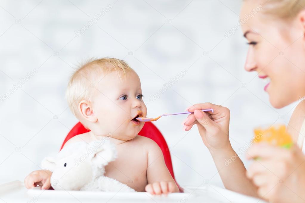mother feeding her baby girl by spoon Stock Photo - Alamy