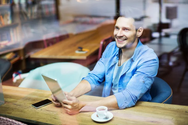 Uomo che utilizza tavoletta digitale al caffè — Foto Stock