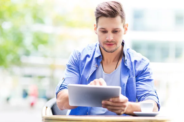 Uomo che utilizza tavoletta digitale al caffè — Foto Stock