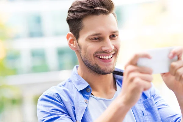 Jonge man met behulp van mobiele telefoon buiten — Stockfoto