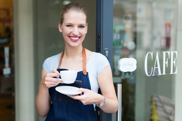 Woman standing in front of coffee shop — Stock Photo, Image