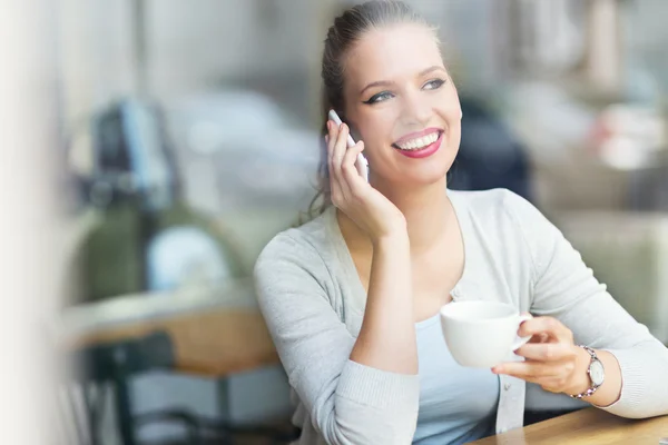 Femme utilisant un téléphone portable au café — Photo