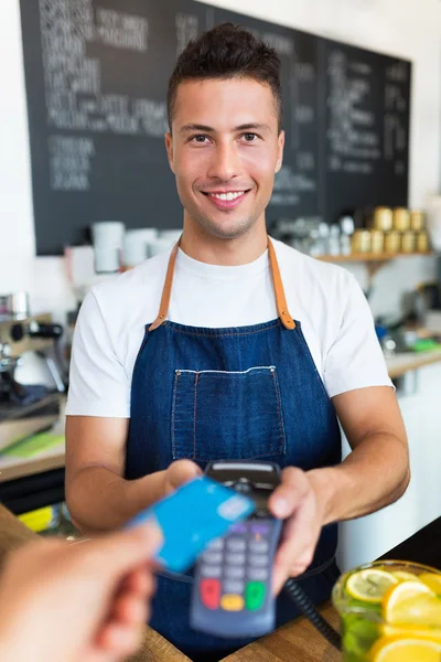 Man holding credit card reader at cafe