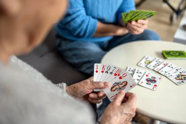 Huzurevinde kart oynayan yaşlı kadınlar, ellerine odaklanın.