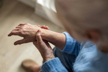 Elindeki acıdan muzdarip kıdemli kadın.