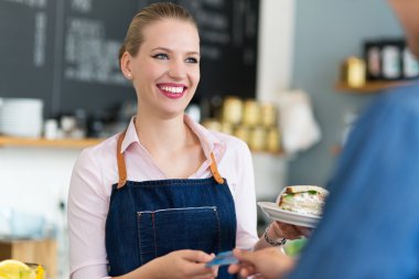 Barista serving customer in coffee shop clipart
