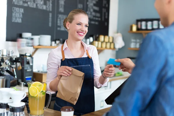 Barista portie klant in koffie winkel — Stockfoto