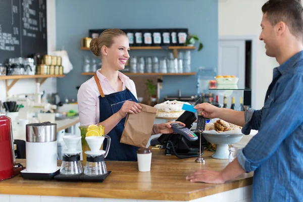 Barista servindo cliente em café — Fotografia de Stock