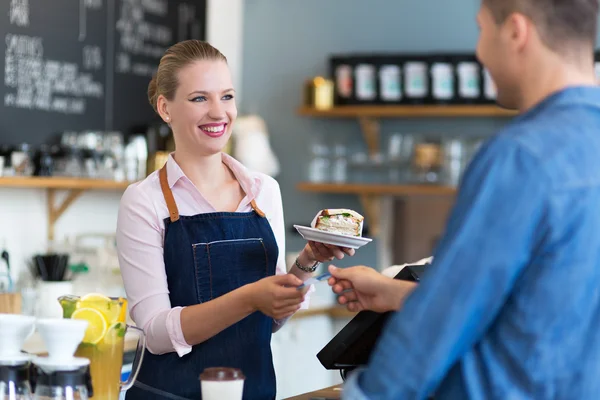 Barista sirviendo al cliente en la cafetería — Foto de Stock