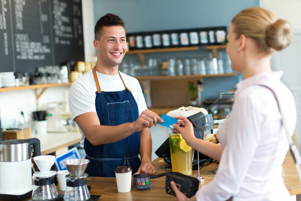 Barista serving customer in coffee shop