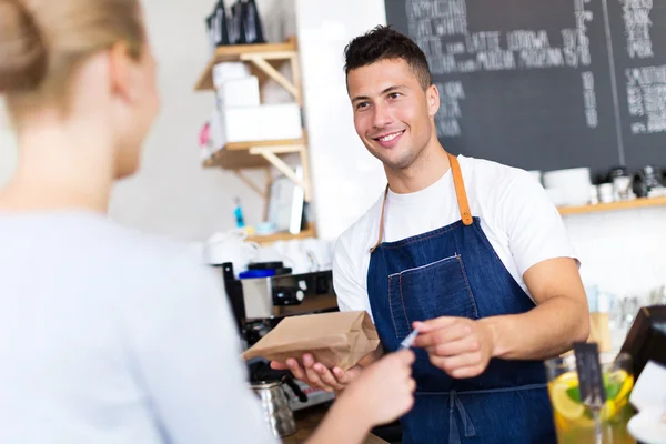 Barista slouží zákazníkovi v kavárně — Stock fotografie