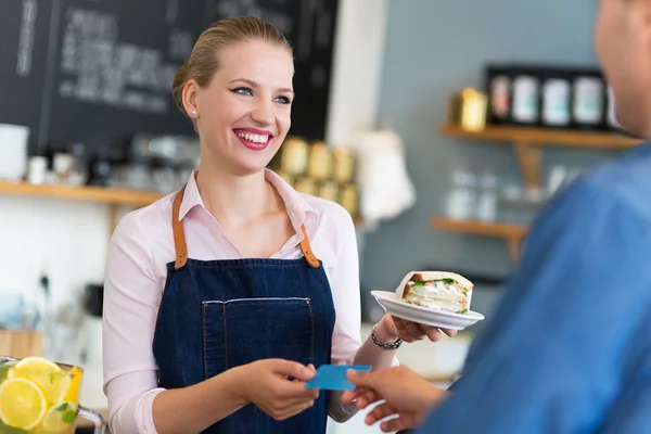 Barista sirviendo al cliente en la cafetería Imágenes De Stock Sin Royalties Gratis