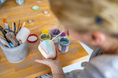 Tanımlanamayan Bayan Potter atölyesinde bir çömlek süslüyor.