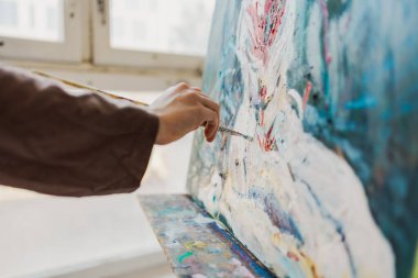 Yağlı boyalarla kadın ressamların el resmine yakın plan.