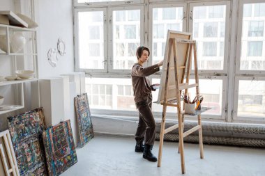 Stüdyoda resim yapan kadın sanatçı.