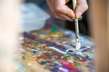 Yağlı boyalarla kadın ressamların el resmine yakın plan.