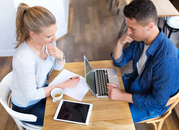 Casal jovem usando laptop no café — Fotografia de Stock