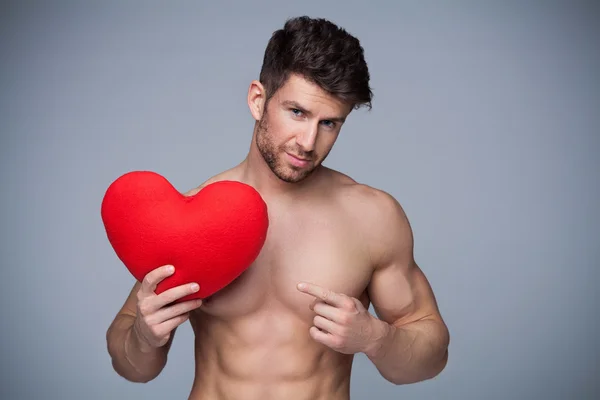 Homem muscular segurando forma do coração — Fotografia de Stock