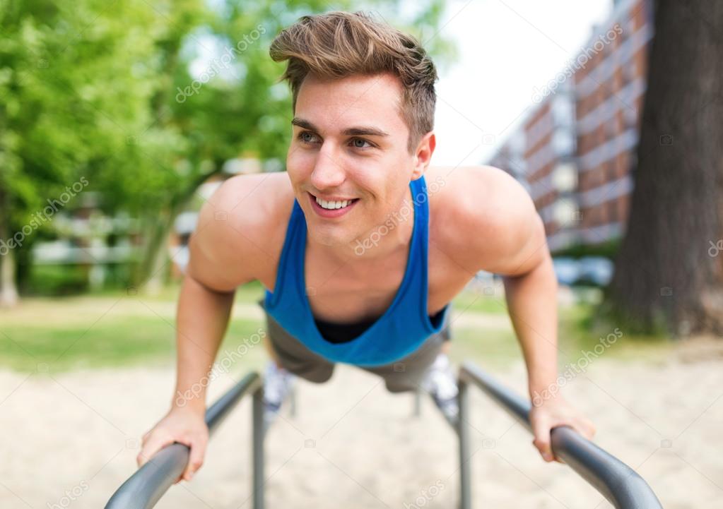 Young man exercising at outdoor gym